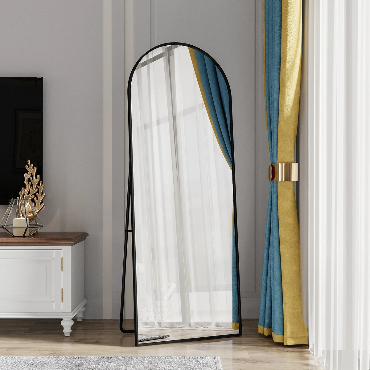 Miroir psyché cintré Nesty - Cadre noir au salon, reflet d'un rideau voile et de tentures bleu et or