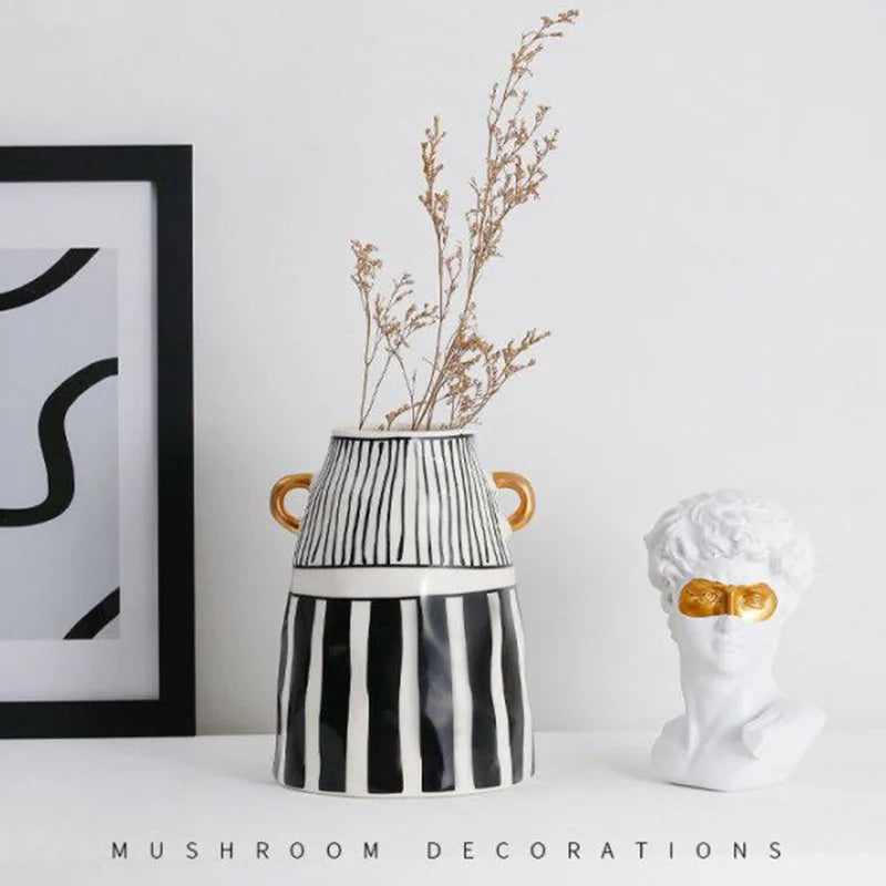 Vase en céramique rayé — silhouette abstraite haute - Nesty - Grand modèle avec brins séchés dorés, à côté d'un buste décoratif blanc et doré