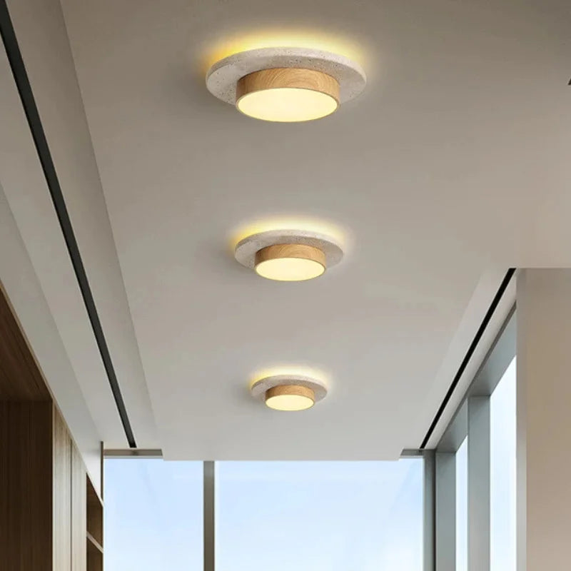 Plafonnier rond en pierre et bois Nesty - Trois plafonniers installés en alignement dans un couloir vitré