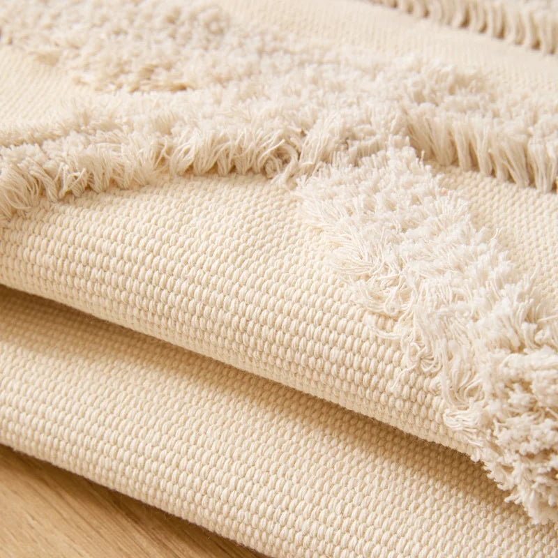 Tapis noué main à franges — motif ethnique - Nesty, tapis plié empilé montrant le motif losange en relief et les franges