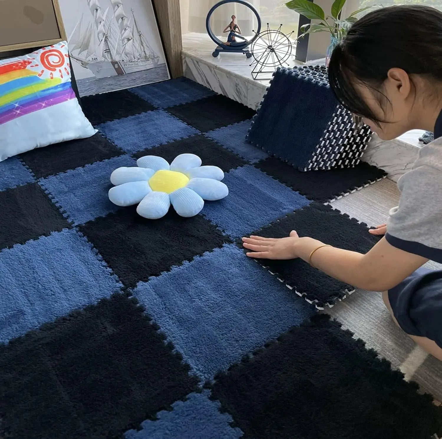 Tapis puzzle mousse moelleux — lot de 10 dalles - Nesty, dalles bleu marine et noir assemblées en damier, une femme en train de les emboîter