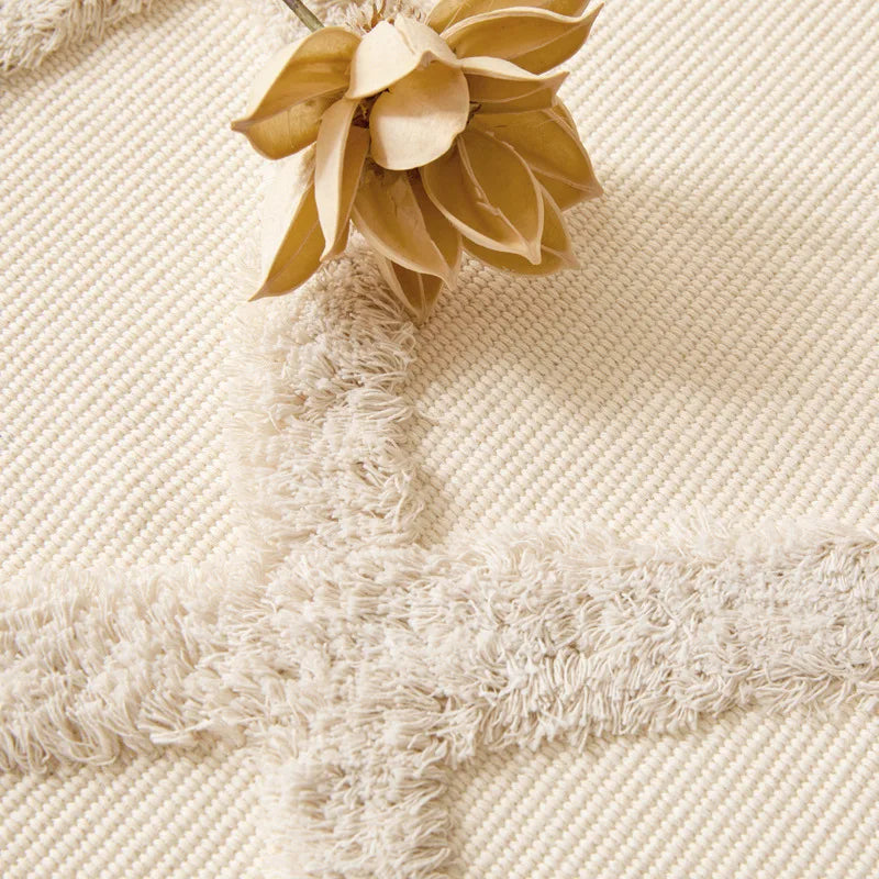 Tapis noué main à franges — motif ethnique - Nesty, gros plan sur le motif en relief et les franges, avec une fleur séchée