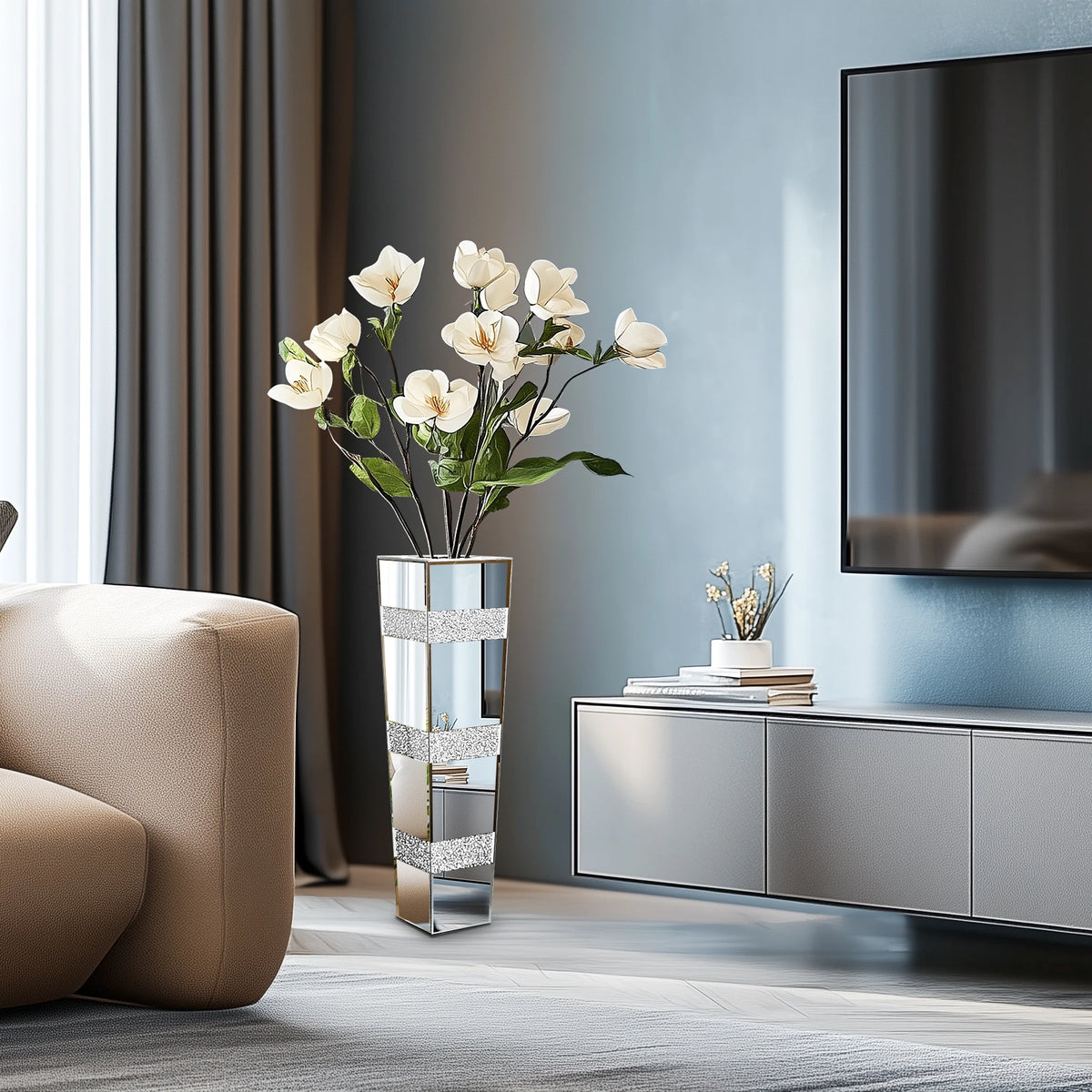 Vase sol en verre facetté, finition miroir - Nesty - Vase haut miroir à bandes strassées garni de fleurs blanches, dans un salon avec canapé beige et meuble TV gris