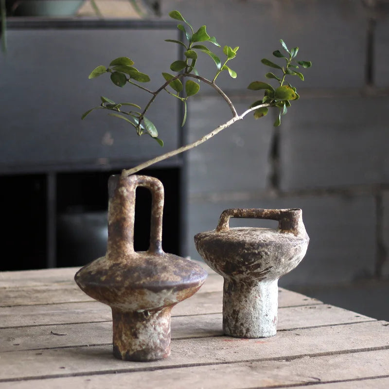 Vase en terre cuite, esprit rétro et brut Nesty, deux vases terre cuite brute effet rouille avec anse, l'un garni d'une branche feuillue, sur table en bois