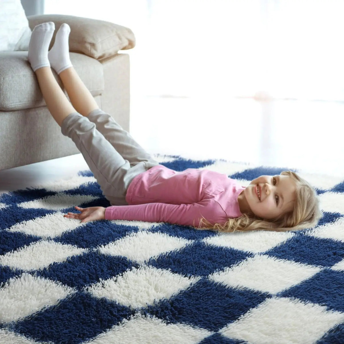 Tapis à damier moelleux pour salon - Nesty, damier bleu marine et blanc avec une fillette allongée dessus