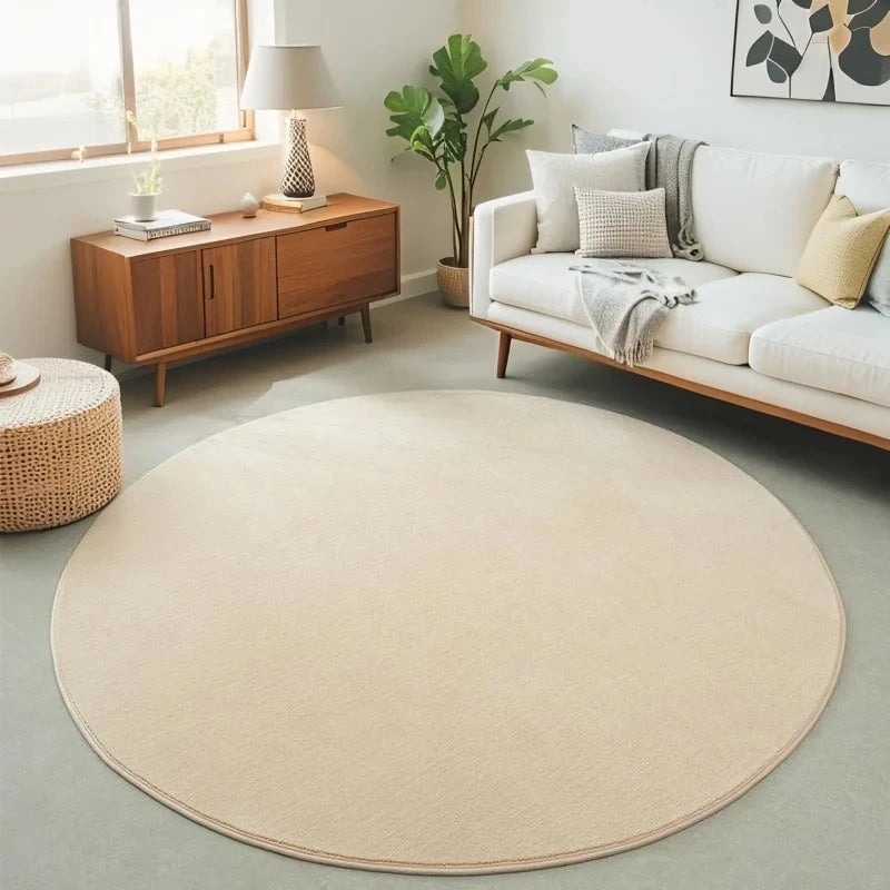 Tapis rond en velours corail — coloris unis - Nesty, coloris ivoire dans un salon avec canapé blanc et plante verte