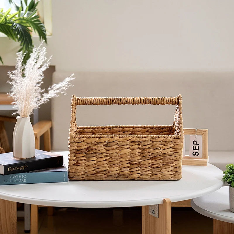 Panier de rangement suspendu en corde tressée Nesty, panier vide posé sur une table basse ronde avec livres et vase de fleurs séchées