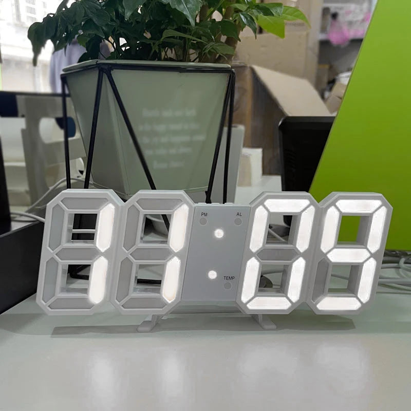 Horloge murale LED digitale Nesty - Coloris blanc, posée sur un bureau