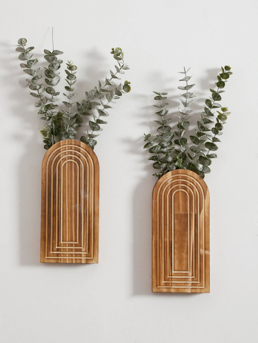 Vase mural en bois arqué, esprit bohème Nesty, deux tailles fixées au mur, vue rapprochée du motif en arche gravé, garnies d'eucalyptus