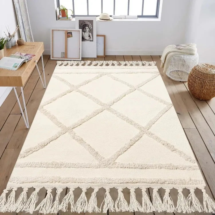 Tapis tufté en coton — tissé à la main - Nesty, tapis écru tufté à motif losange en relief et franges, dans une pièce avec bureau et pouf en osier