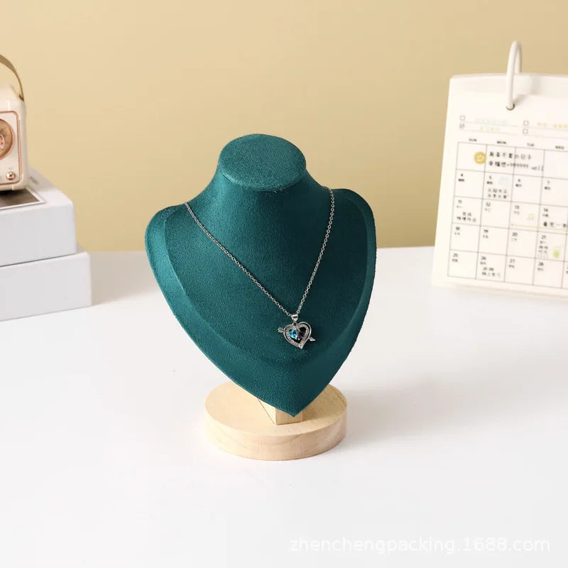 Buste en bois Nesty - Présentoir en velours vert avec collier pendentif cœur argenté, calendrier et radio en fond