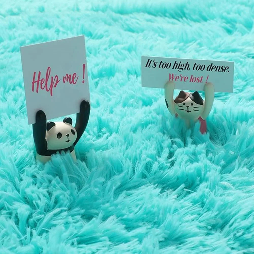 Gros plan sur la texture d'un tapis en fausse fourrure turquoise, avec deux petites figurines (panda et chat) tenant des pancartes humoristiques enfoncées dans le poil épais.