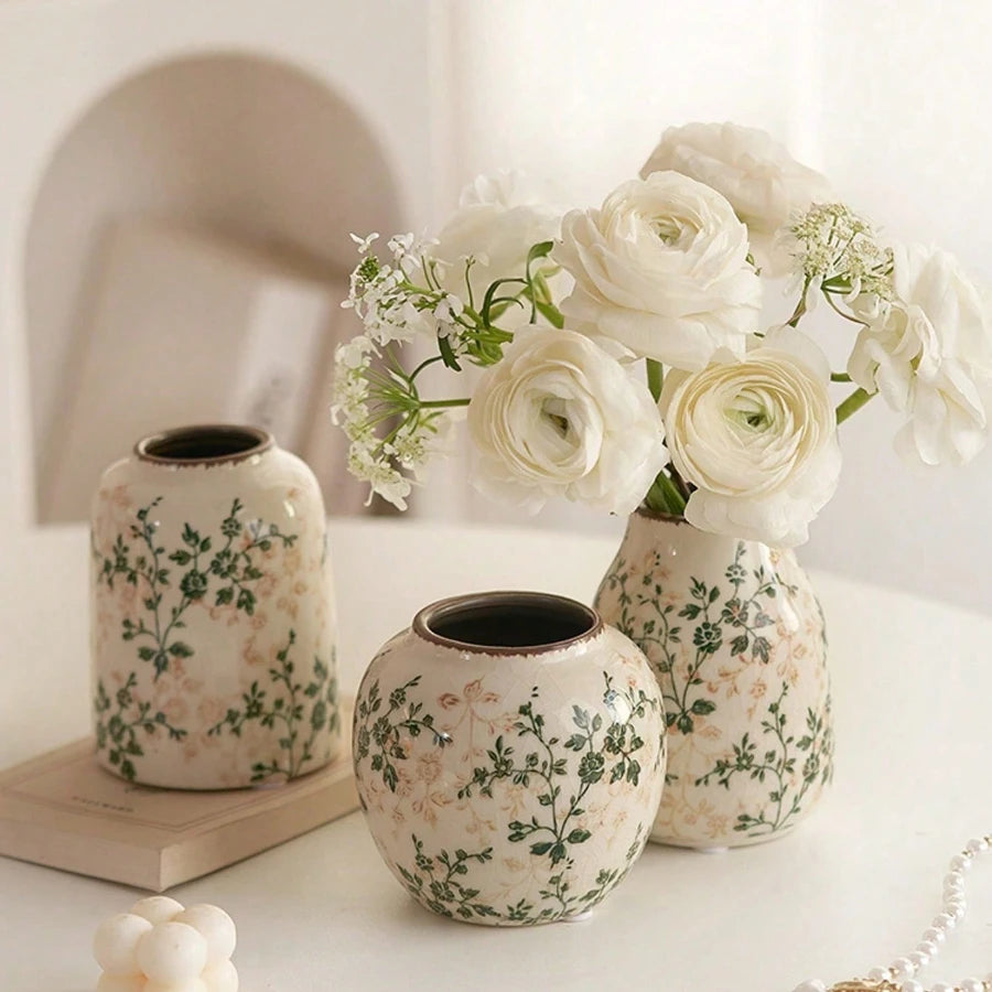 Vase en céramique craquelé, fait main, esprit bohème Nesty, trois vases céramique blanc craquelé à motif floral vert et beige, tailles différentes, l'un garni de roses blanches, sur table