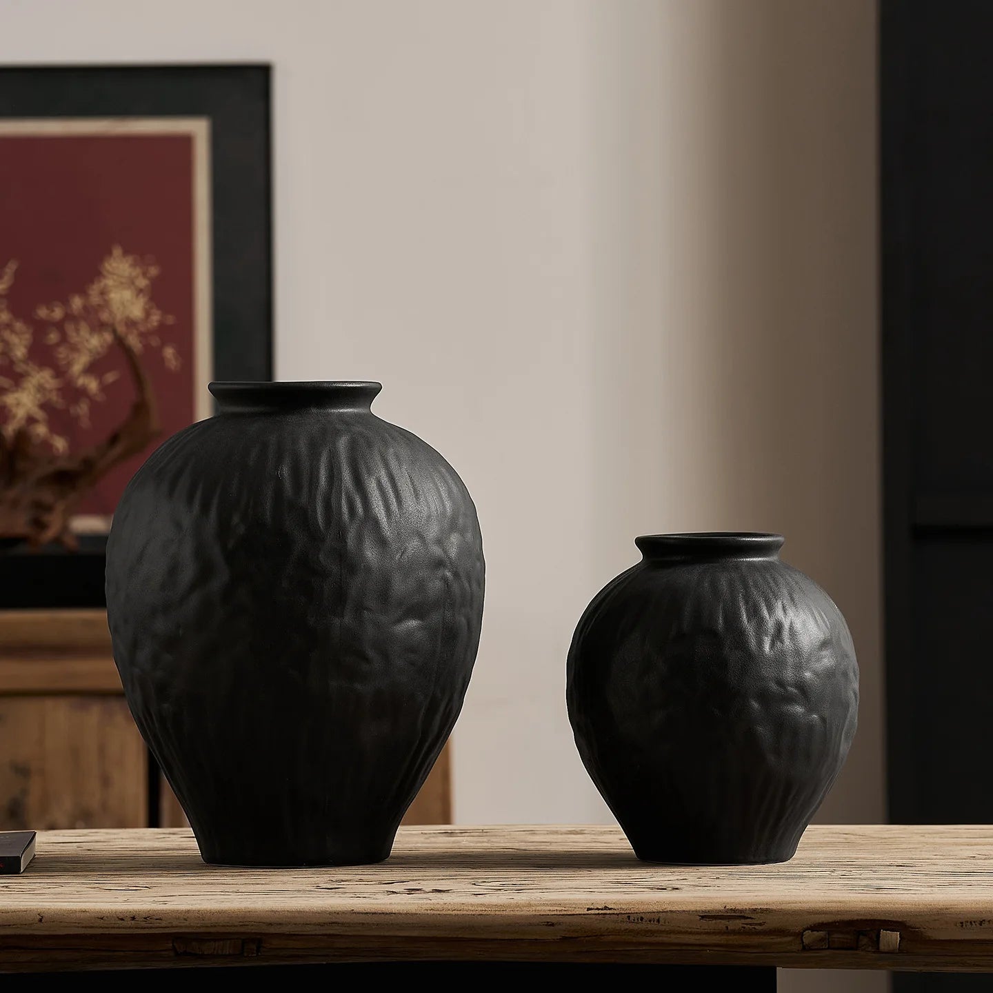 Vase en céramique noir et blanc, esprit wabi-sabi pour fleurs séchées Nesty, deux tailles en noir texturé sur une console en bois, tableau à branche dorée en arrière-plan