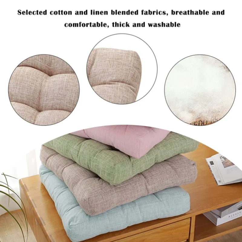 Grand coussin de sol carré en coton et lin, esprit tatami épais Nesty, médaillons montrant la texture matelassée et le tissu coton-lin, pile de coussins carrés capitonnés de coloris rose, vert, taupe et bleu clair sur meuble en bois