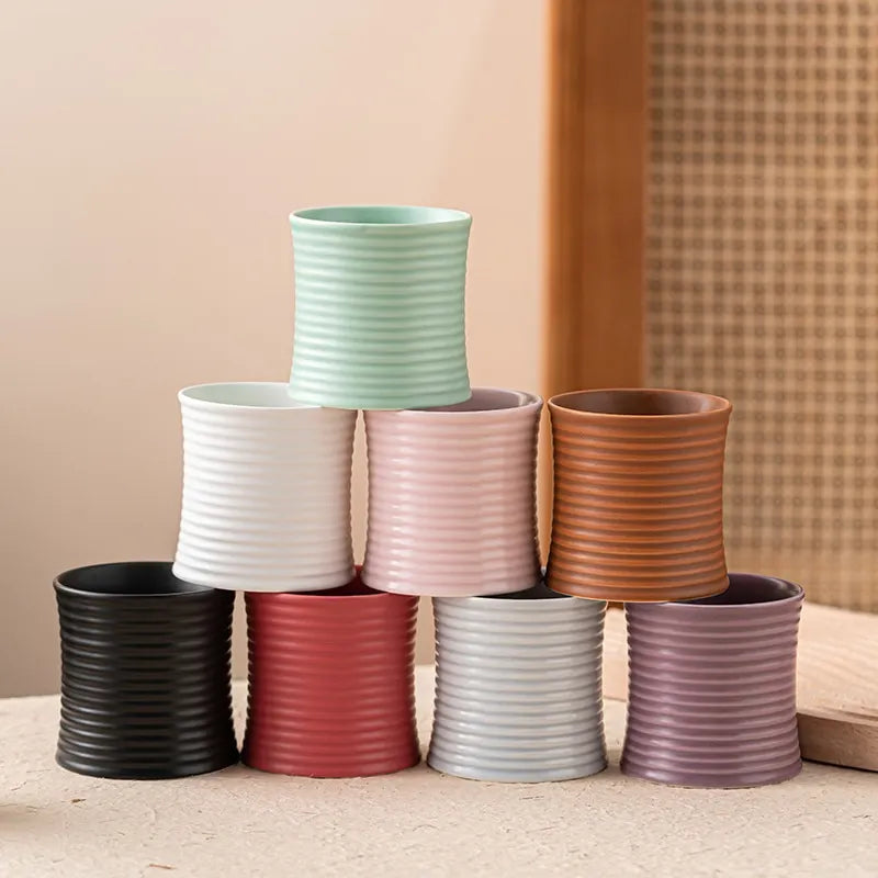 Photophore jarre en céramique striée Nesty - Assortiment de huit coloris empilés en pyramide, vert d'eau, rose, terracotta, noir, rouge, gris et prune