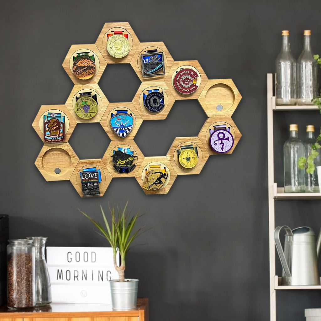 Étagère murale hexagonale en bois Nesty - Nid d'abeille, grand assemblage d'hexagones sur un mur sombre affichant une collection de médailles de course, près d'étagères et de bouteilles