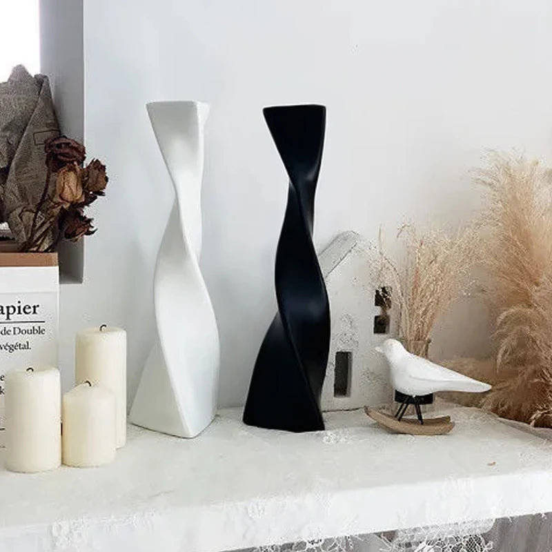 Vase céramique haut et torsadé Nesty - Coloris blanc et noir côte à côte, près de roses séchées, bougies et figurine d'oiseau