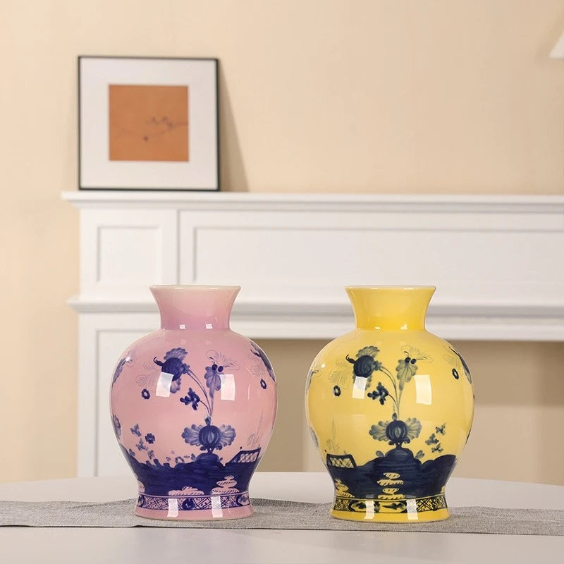 Vase en porcelaine peint à la main, motif bleu et blanc Nesty, deux vases identiques, l'un rose l'un jaune, à motifs floraux bleus, côte à côte