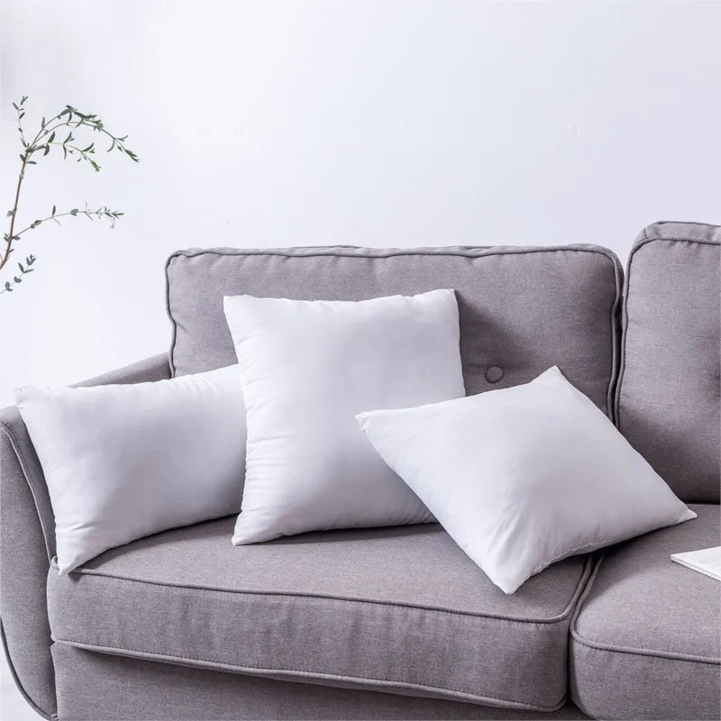 Coussin de rembourrage blanc Nesty - Trois tailles posées sur un canapé