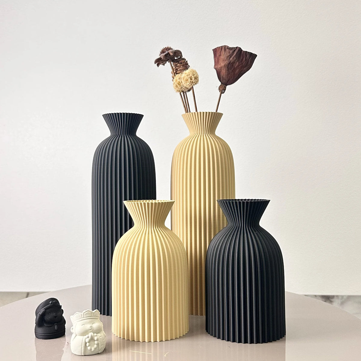 Duo de vases à motif ondulé pour fleurs séchées Nesty, quatre vases côtelés noirs et beiges, le plus grand beige garni de fleurs séchées brunes