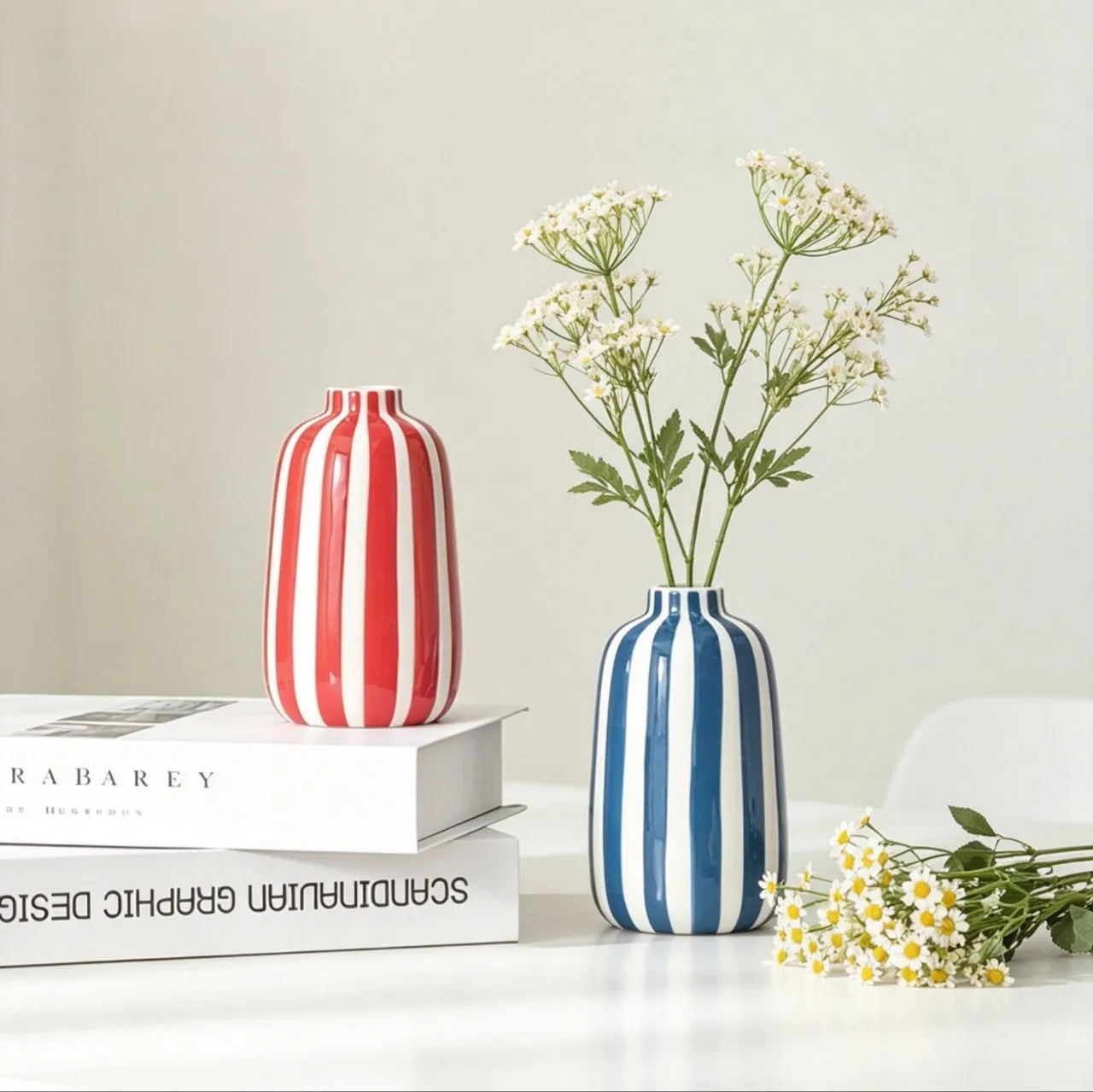 Vase en céramique à rayures géométriques Nesty - Modèle rouge avec marguerites sur livres, modèle bleu avec fleurs blanches