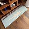 Tapis de chevet long à motif rétro Nesty - Bleu pastel motif étoile, posé au pied d'une bibliothèque en bois