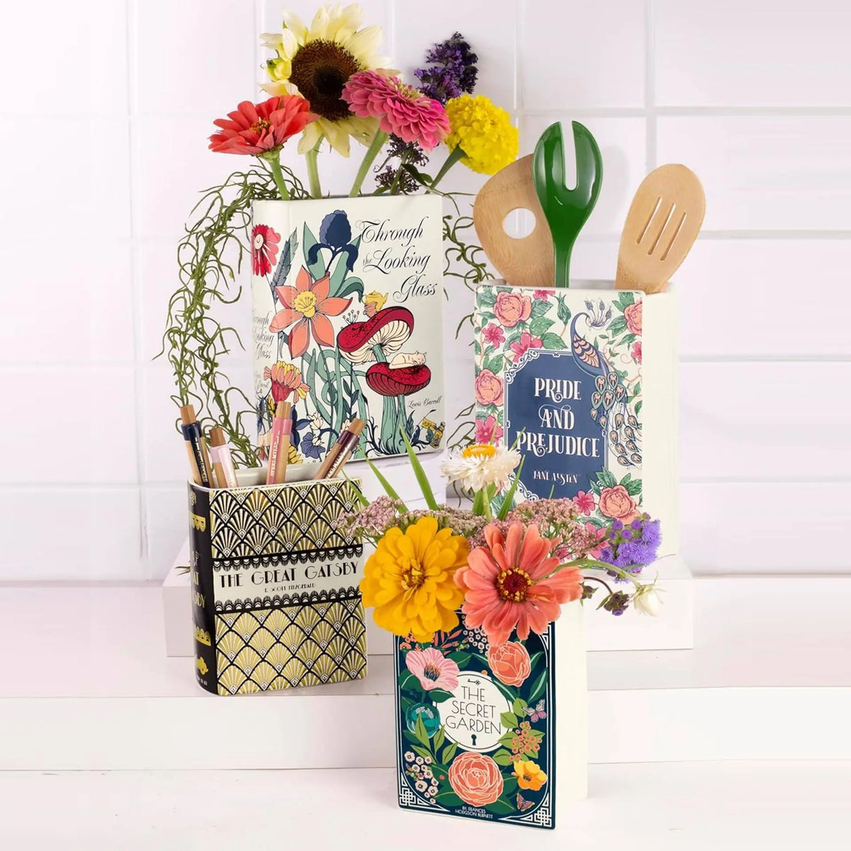 Vase en céramique en forme de livre, décoration pour bibliothèque Nesty, vases en forme de livre fleuris ("Through the Looking Glass", "The Secret Garden") garnis de fleurs jaunes et oranges et d'ustensiles de cuisine en bois, sur crédence carrelée