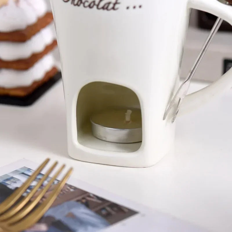 Mug à fondue en céramique, avec fourchette Nesty, gros plan sur le compartiment à bougie chauffe-plat allumée sous un mug blanc, avec fourchette à fondue