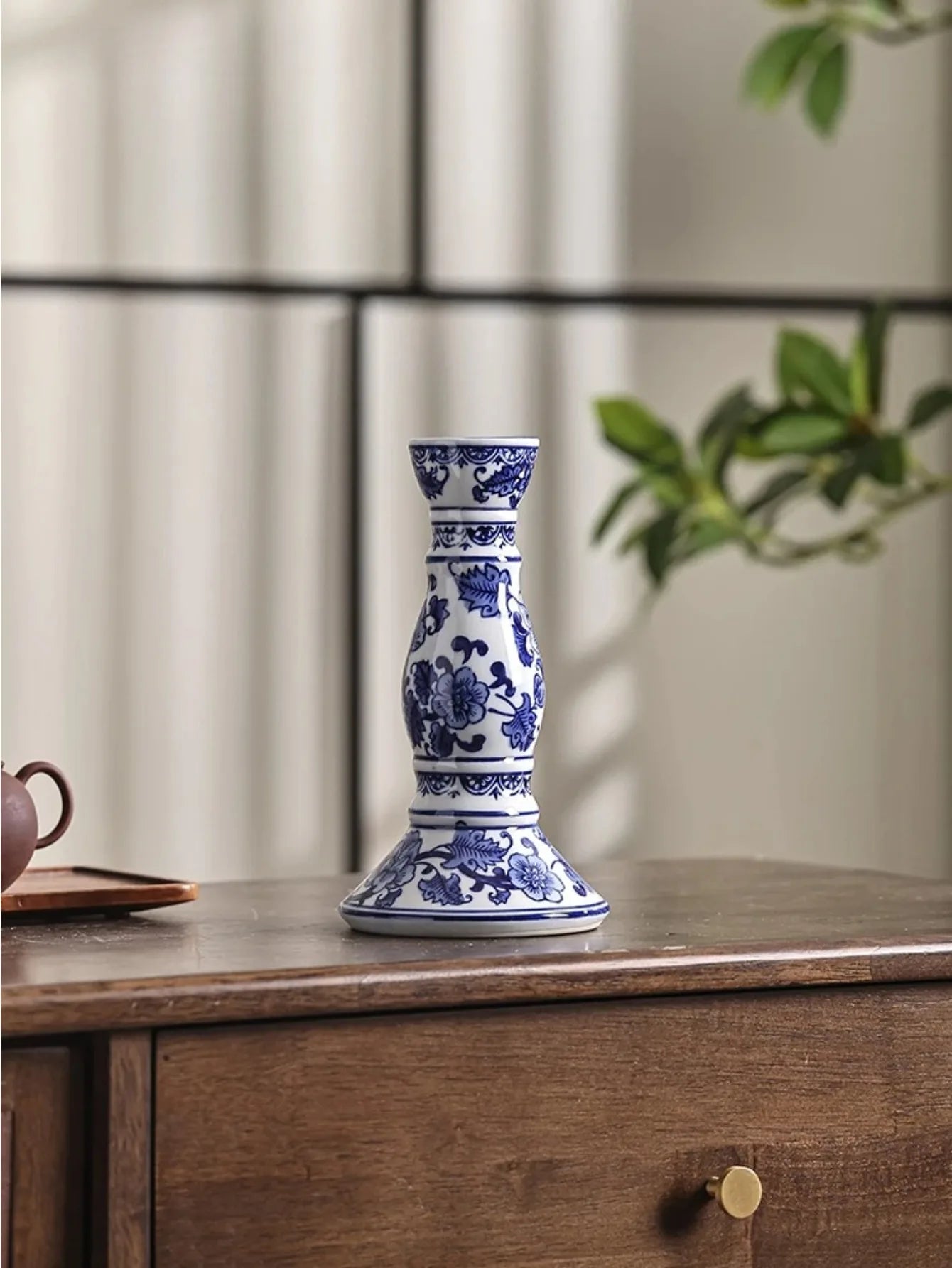 Bougeoir en porcelaine bleue et blanche Nesty - Bougeoir seul à motifs floraux bleus, branche de feuillage vert en arrière-plan