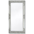Miroir mural baroque Nesty - Vue de face sur fond blanc, cadre argenté sculpté à motifs floraux