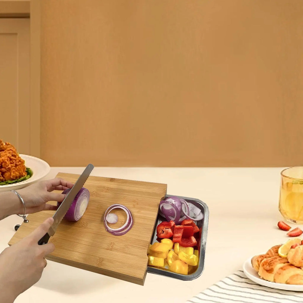 Planche à découper en bois avec plateau de service intégré Nesty, en situation sur une table, assiette de poulet frit et fraises et verre de boisson à côté
