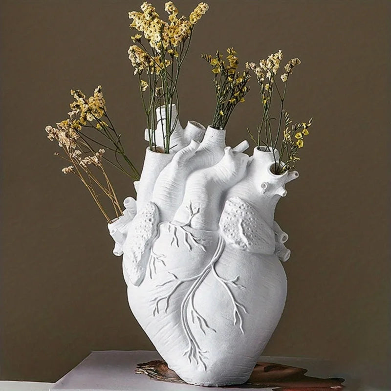 Vase en résine forme cœur, style nordique - Nesty - Coloris blanc en gros plan avec brins de fleurs séchées jaunes, posé sur un livre, fond marron