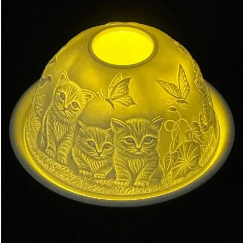 Photophore dôme en porcelaine fine gravé de chatons et papillons, veilleuse translucide allumée, sur fond noir - Nesty