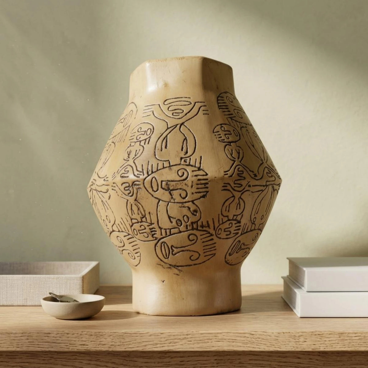 Vase en résine sculptée peint à la main, esprit wabi-sabi Nesty, vase jaune ocre à motifs gravés, gros plan de face, sur étagère en bois avec coupelle et livres