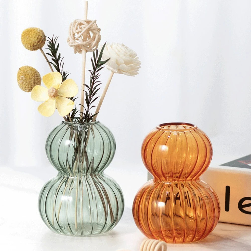 Vase en verre forme calebasse, rayures verticales - Nesty - Coloris vert sauge et ambre côte à côte, le vert garni de fleurs séchées jaunes et blanches