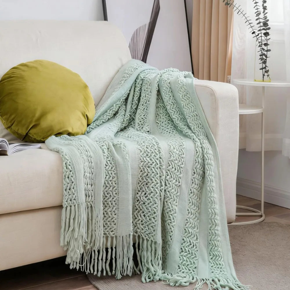 Plaid léger tricoté vert d'eau Nesty - Drapé sur canapé beige avec coussin rond moutarde, motif torsadé et franges