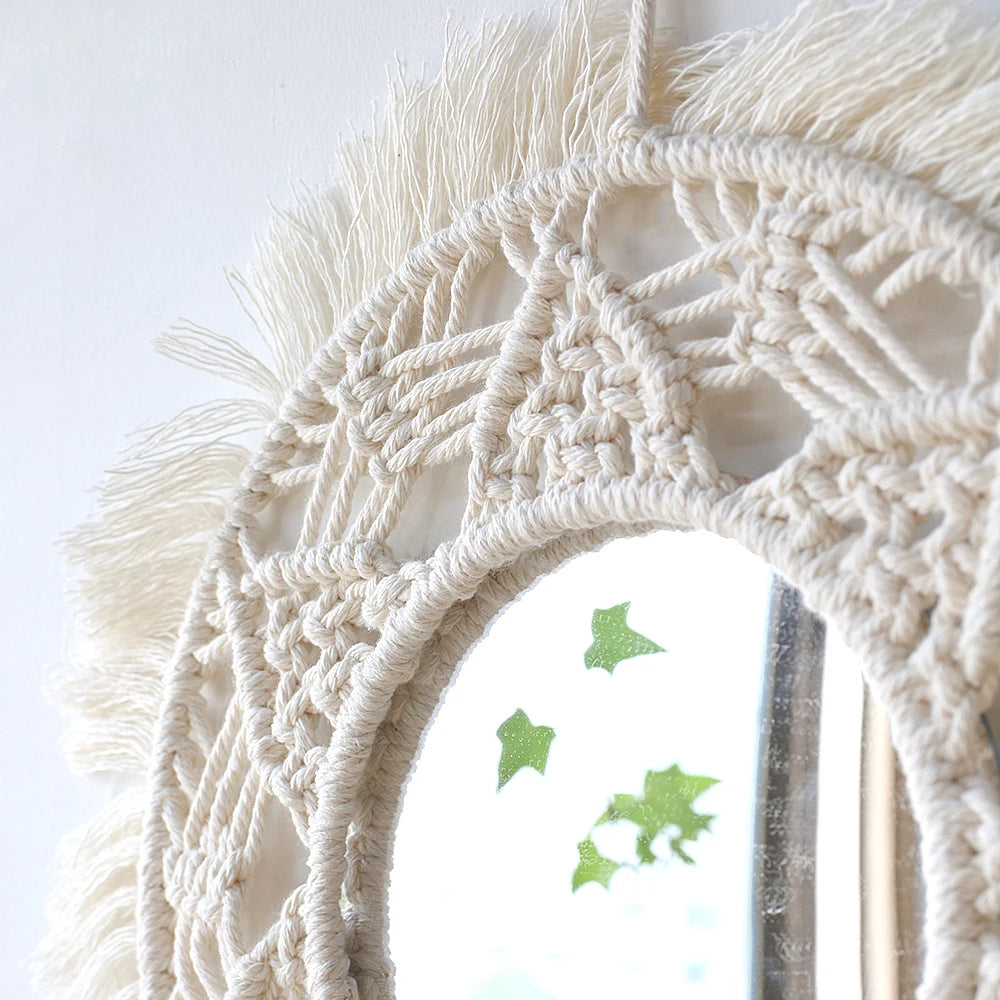 Miroir mural rond macramé blanc, gros plan sur le motif tressé et les franges, avec autocollants feuilles vertes sur le miroir - Nesty