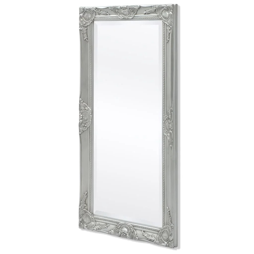 Miroir mural baroque Nesty - Vue de trois quarts sur fond blanc, cadre argenté sculpté