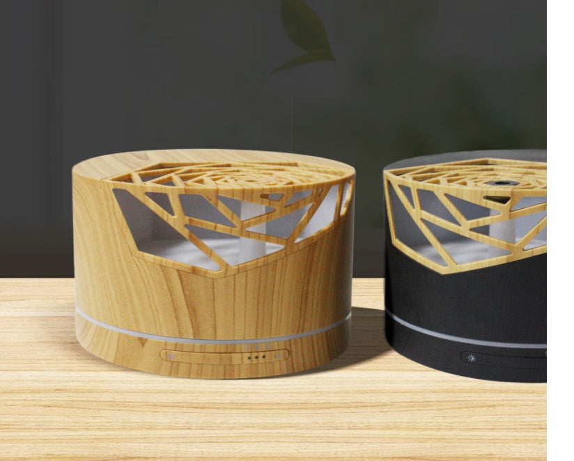 Diffuseur d'huiles essentielles Nesty - Les deux finitions côte à côte, effet bois clair et noir, sur un plan en bois
