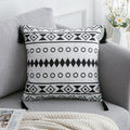 Housse de coussin en polyester satiné Nesty - Motif ethnique à losanges et cercles noirs, coins à glands, sur un canapé gris