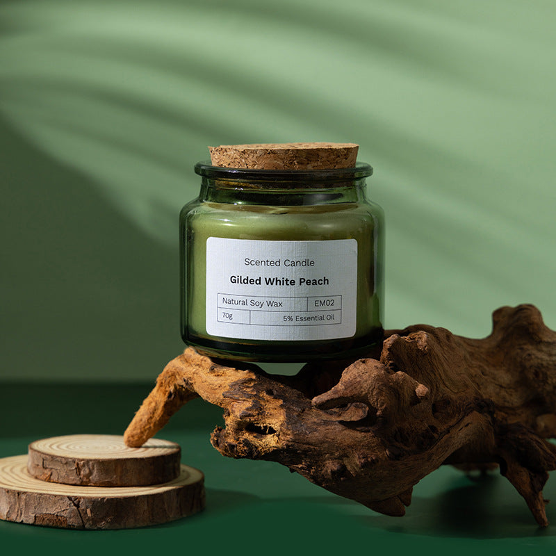 Bougie parfumée en cire de soja Nesty - Parfum Gilded White Peach, posée sur bois flotté avec sous-verres